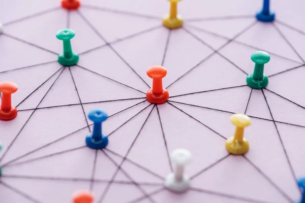 Enfoque selectivo de los pines de empuje conectados con cuerdas aisladas en rosa, concepto de red — Stock Photo