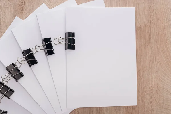Top view of stacks of blank paper with metal binder clips and copy space on table — Stock Photo