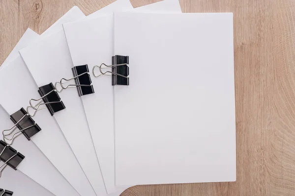 Vista superior de pilas de papel en blanco con clips de aglutinante de metal y espacio de copia en la mesa - foto de stock