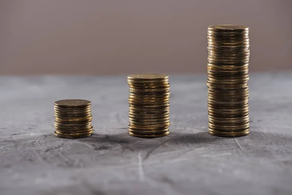 Monedas de oro dispuestas en filas en la mesa aisladas en marrón - foto de stock