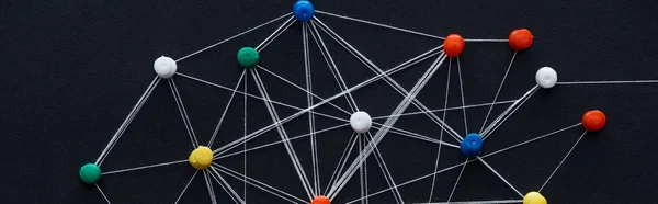 Панорамний знімок штифтів, з'єднаних струнами, ізольованими на чорному, концепція мережі — стокове фото