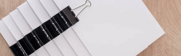 Panoramic shot of stacks of blank paper with metal binder clips and copy space — Stock Photo