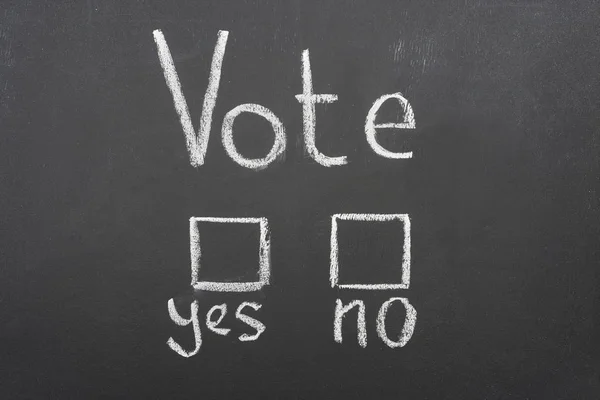 Top view of white vote, yes and no words on black chalkboard — Stock Photo