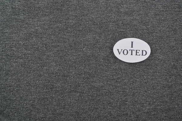 Top view of badge with i voted lettering on textured background — Stock Photo