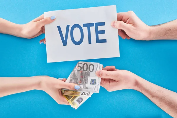 Частковий погляд на чоловіка, який дає хабар для голосування жінці на синьому фоні — стокове фото