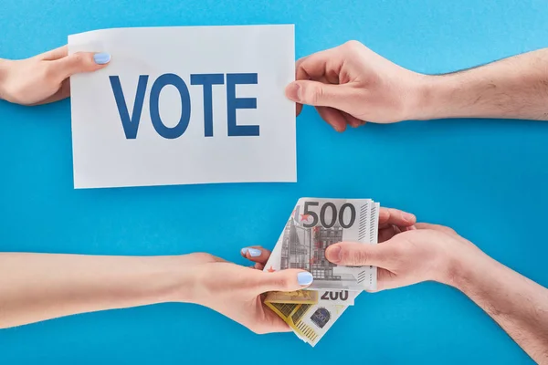 Partial view of woman giving bribe for vote to man on blue background — Stock Photo