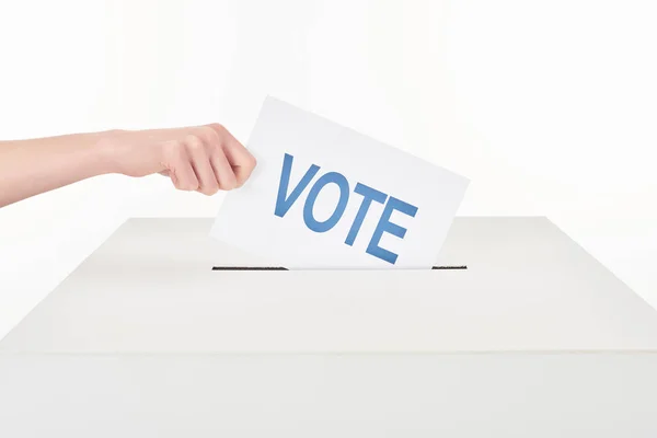 Visão parcial da mulher colocando voto em caixa isolada em branco — Fotografia de Stock