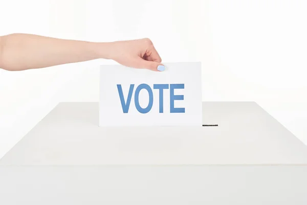 Vista cortada de mulher colocando voto em caixa isolada em branco — Fotografia de Stock