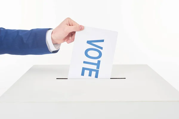 Recortado vista de hombre poniendo tarjeta con voto en caja aislado en blanco - foto de stock