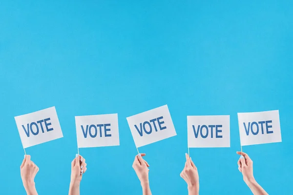 Partial view of women holding flags with vote lettering on blue background — Stock Photo