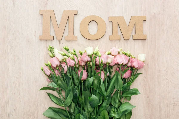 Вид зверху на квіти еустоми з дерев'яною мамою слово на столі — стокове фото