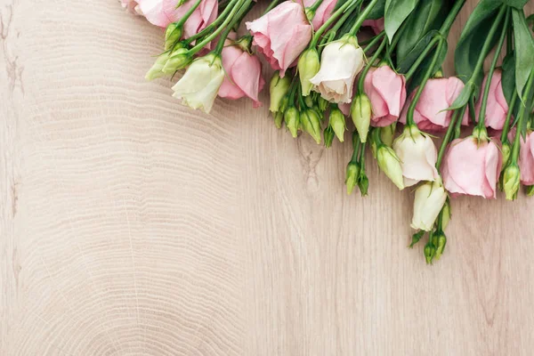 Top view of eustoma flowers bouquet on wooden table with copy space — Stock Photo