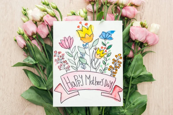 Вид зверху на квіти еустоми та листівки з днем щасливих матерів на столі — стокове фото
