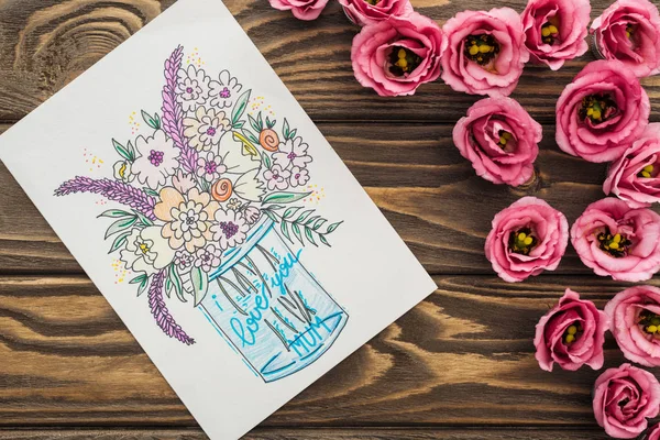 Vista superior de flores eustoma y tarjeta con te amo mamá letras en mesa de madera texturizada - foto de stock