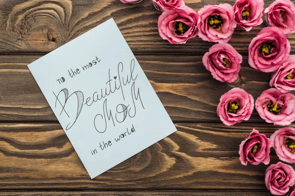 Vista superior de flores eustoma e cartão com a mãe mais bonita do mundo lettering — Fotografia de Stock