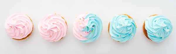Panoramic shot of tasty colorful cupcakes with sprinkles Isolated On White — Stock Photo