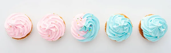 Tiro panorâmico de cupcakes coloridos saborosos com polvilhas isoladas em branco — Fotografia de Stock