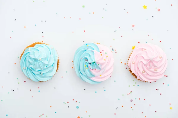 Plan panoramique de délicieux cupcakes colorés avec des aspersions isolées sur blanc — Photo de stock