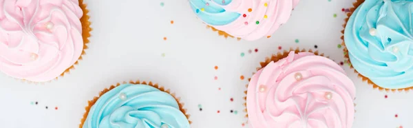 Colpo panoramico di deliziosi cupcake colorati con spruzzi isolati su bianco — Foto stock