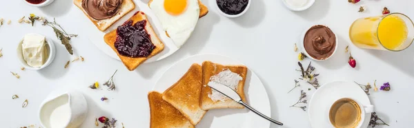 Панорамний знімок тарілок зі смачними тостами біля напоїв на білому — стокове фото