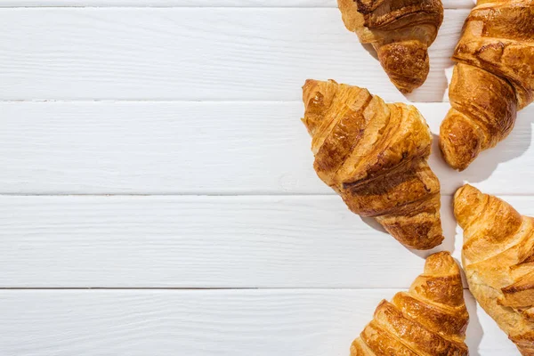 Vista dall'alto di croissant gustosi e freschi su superficie bianca — Foto stock