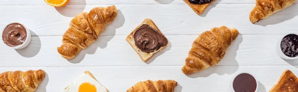 Panoramic shot of sweet croissants and tasty toast on white — Stock Photo