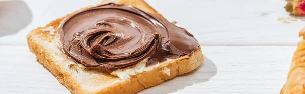 Panoramic shot of sweet toast with chocolate cream on white — Stock Photo