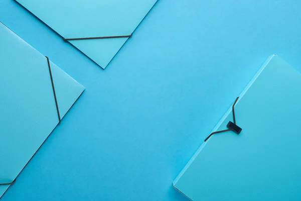 Вид зверху паперових зв'язувачів ізольовано на синьому з простором для копіювання — стокове фото