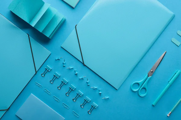 Flat lay of paper binders and various arranged stationery isolated on blue — Stock Photo