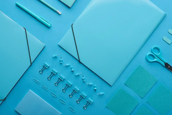 Flat lay of paper binders and organized stationery isolated on blue — Stock Photo