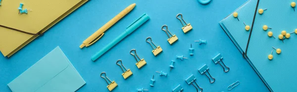 Panoramic shot of colorful organized stationery isolated on blue — Stock Photo