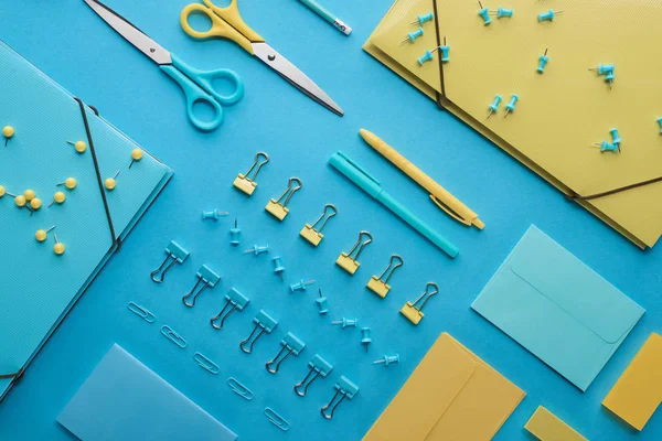 Vista superior de vários artigos de papelaria coloridos isolados em azul — Fotografia de Stock