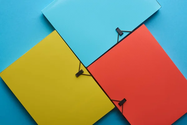 Vista superior de pastas de papel coloridas dispostas em azul — Fotografia de Stock