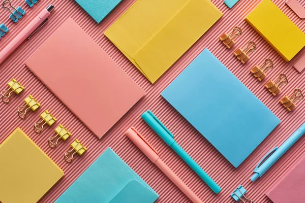 Vista superior de los suministros de papelería de colores en rosa - foto de stock
