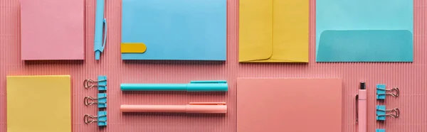 Plano panorámico de varios suministros de papelería de colores en rosa - foto de stock