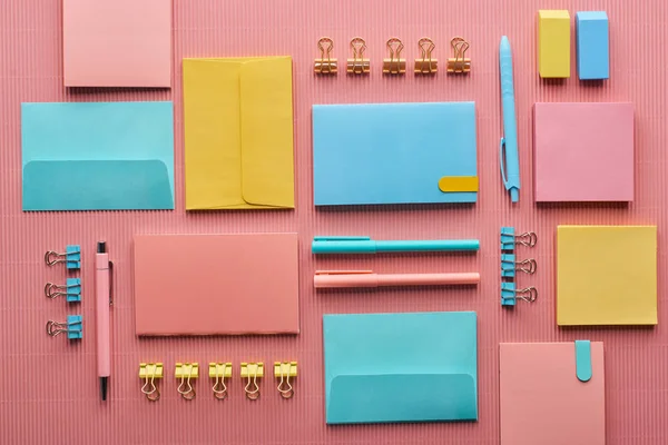 Disposición plana de suministros de papelería de colores en rosa - foto de stock