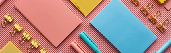 Panoramic shot of colorful stationery supplies on pink — Stock Photo