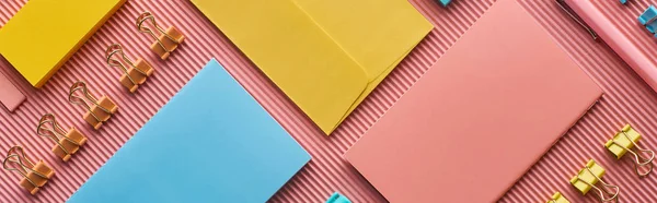 Panoramic shot of colorful stationery supplies on pink — Stock Photo