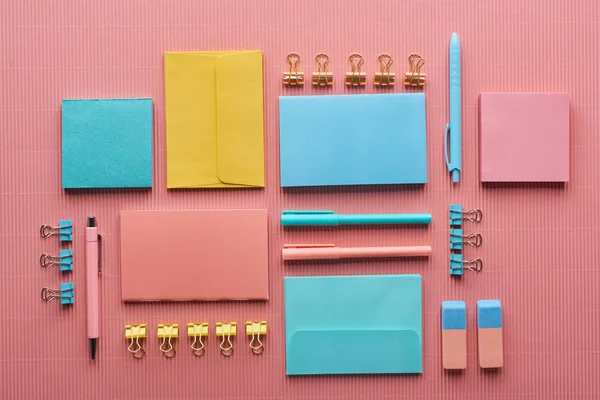 Disposición plana de suministros de papelería de colores en rosa - foto de stock