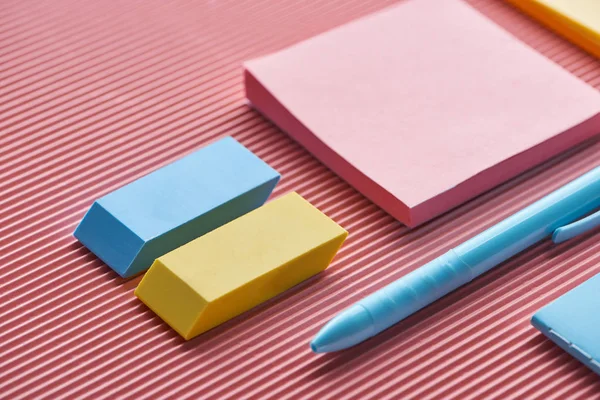 Gros plan de notes collantes, gommes à effacer et stylo sur rose — Photo de stock
