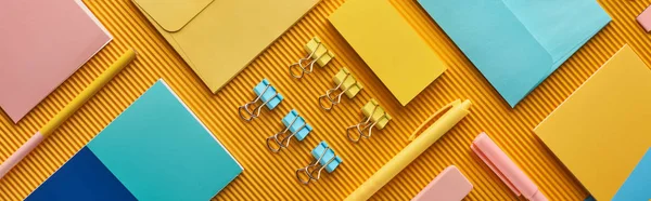 Panoramic shot of colorful arranged office stationery supplies on yellow — Stock Photo