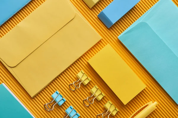 Disposición plana de suministros de papelería de oficina dispuestos multicolores en amarillo - foto de stock