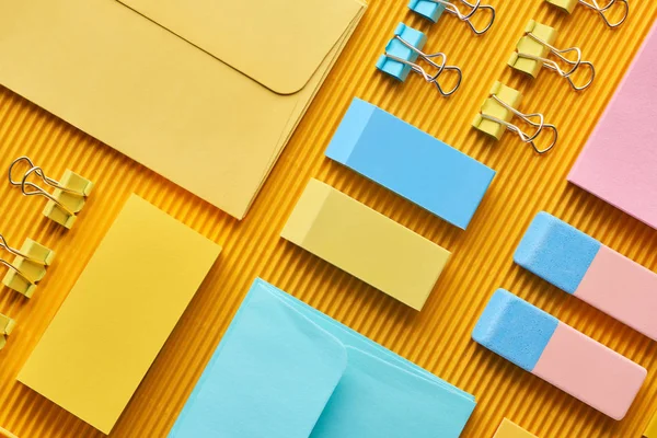 Vue de dessus des fournitures colorées de papeterie de bureau sur jaune — Photo de stock