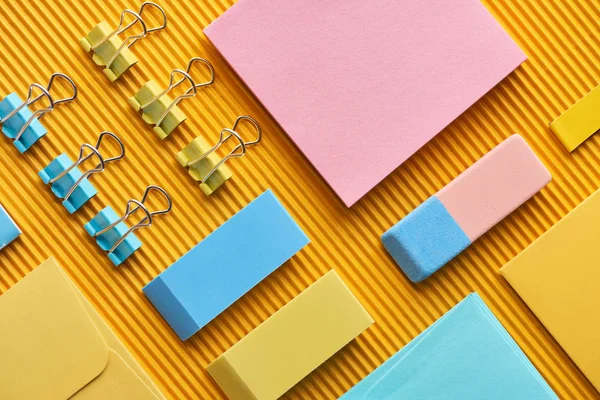 Disposición plana de suministros de papelería dispuestos de colores en amarillo - foto de stock