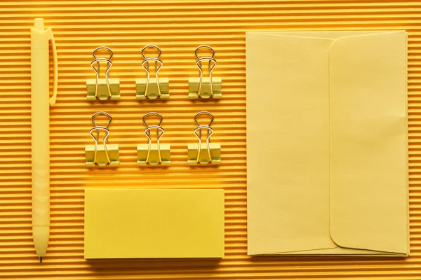 Top view of pen, paper clips and arranged office stationery supplies on yellow — Stock Photo
