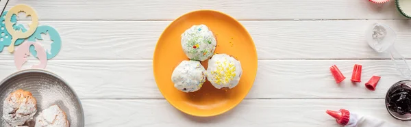 Tiro panorâmico de deliciosos cupcakes e ferramentas de cozimento na mesa de madeira — Fotografia de Stock