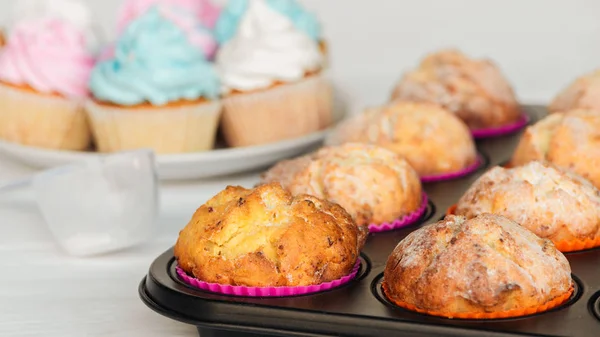 Foco seletivo de cupcakes saborosos com açúcar em pó na bandeja de cupcake — Fotografia de Stock