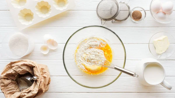 Draufsicht auf Schüssel mit Teig, Küchenutensilien und Zutaten auf dem Tisch — Stockfoto