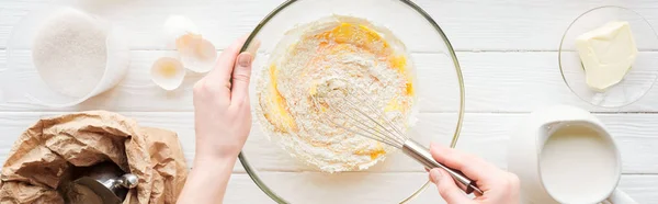 Panoramic shot of woman mixing dough in bowl on table — Stock Photo