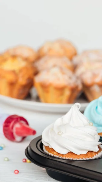 Foco selectivo de deliciosos cupcakes decorados con aspersiones en bandeja de cupcakes aislados en gris - foto de stock